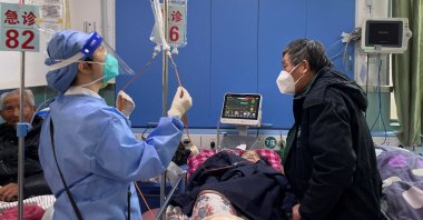 A medical worker checks the IV drip treatment of a patient lying on a bed in the emergency department of a hospital, amid the coronavirus disease (COVID-19) outbreak in Shanghai, China, Jan. 5, 2023. (Reuters Photo)