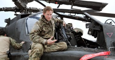 In this file photo dated Dec. 12, 2012, made public on Jan. 21, 2013, Britain's Prince Harry talks to a TV crew after an early morning pre-flight checks on the flight-line, from Camp Bastion, southern Afghanistan. (AP Photo)