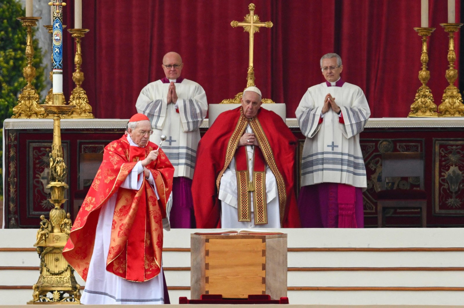 Italian Cardinal Giovanni Battista Re (L) blesses the coffin of Pope Emeritus Benedict XVI, as Pope Francis looks on (C) during his funeral mass at St. Peter&#039;s square in the Vatican, Jan. 5, 2023. (AFP Photo)