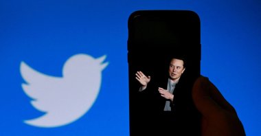 A phone screen displays a photo of Elon Musk with the Twitter logo shown in the background, in Washington, D.C., Oct. 4, 2022. (AFP File Photo)