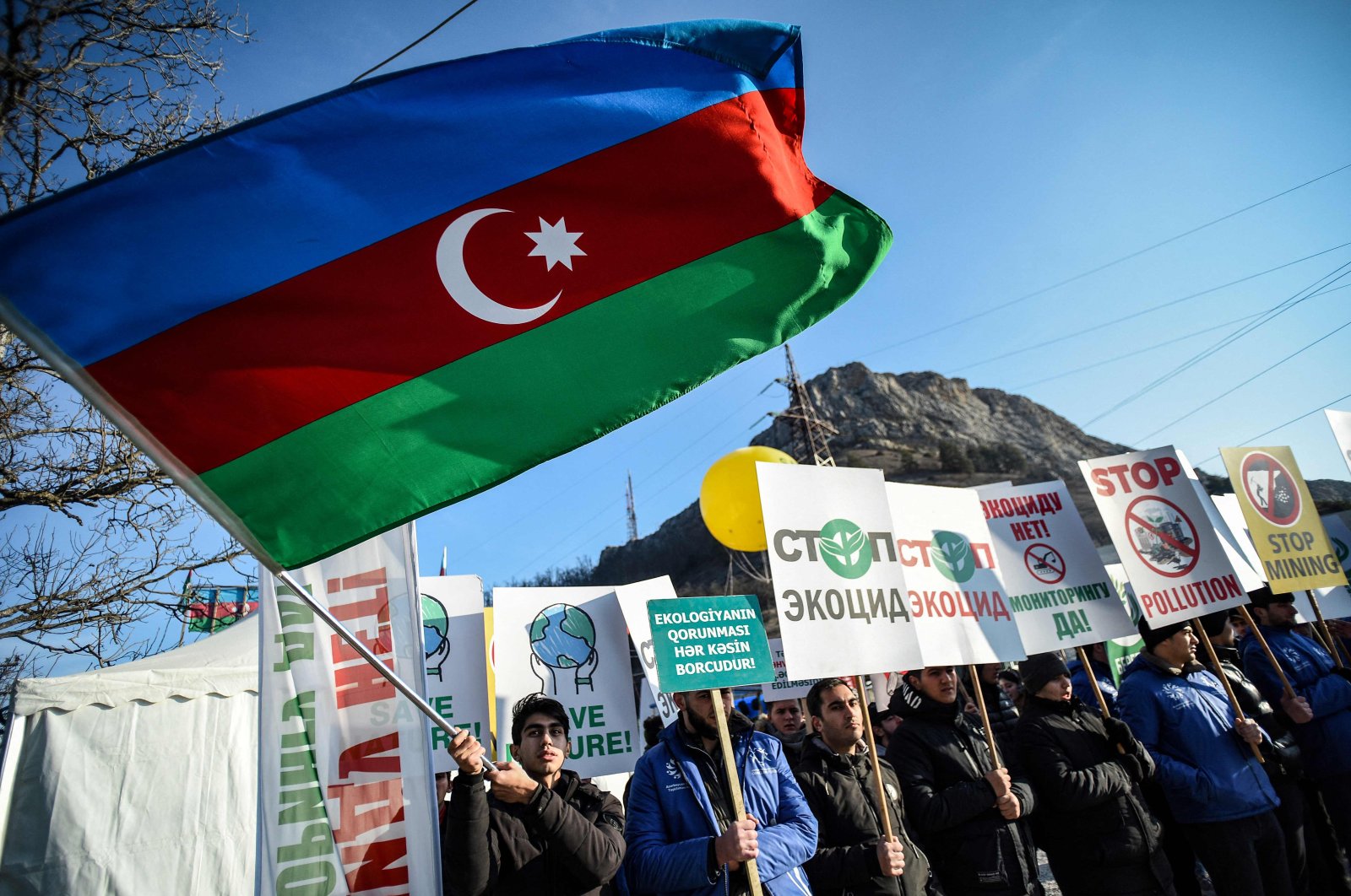 An Azerbaijani environmental activist waves a national flag during a protest against the illegal mining at the Lachin corridor, the Armenian-populated Karabakh region&#039;s only land link with Armenia, Azerbaijan, Dec. 27, 2022. (AFP Photo)