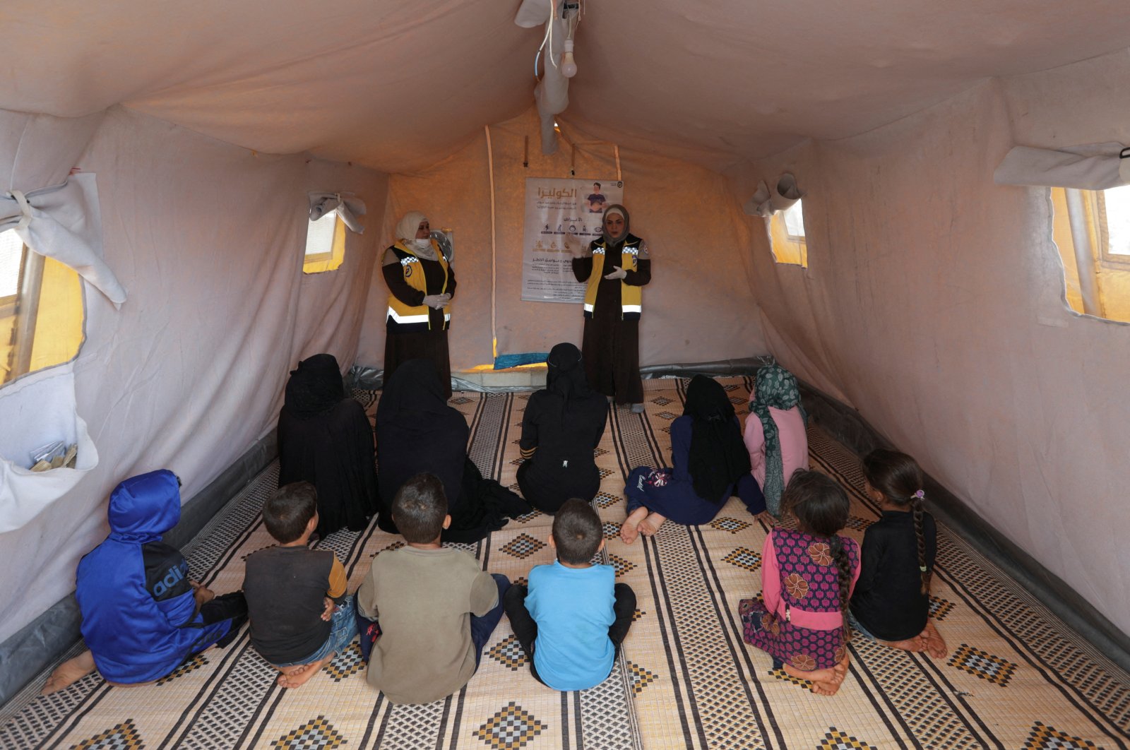 Civil defense members talk to Syrians during a cholera awareness campaign, at a camp in Idlib, Syria, Sept. 24, 2022. (Reuters Photo) 