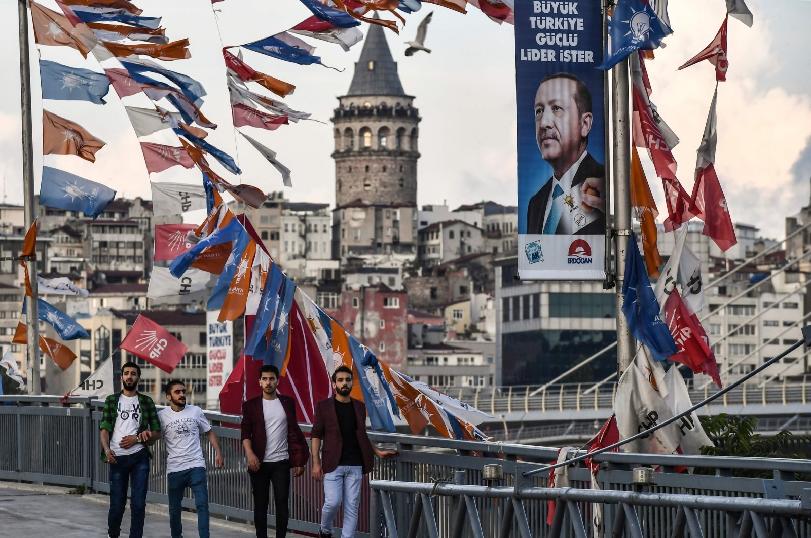 People pass by banners with the portrait of President Erdoğan in Istanbul, June 18, 2018. (AFP)