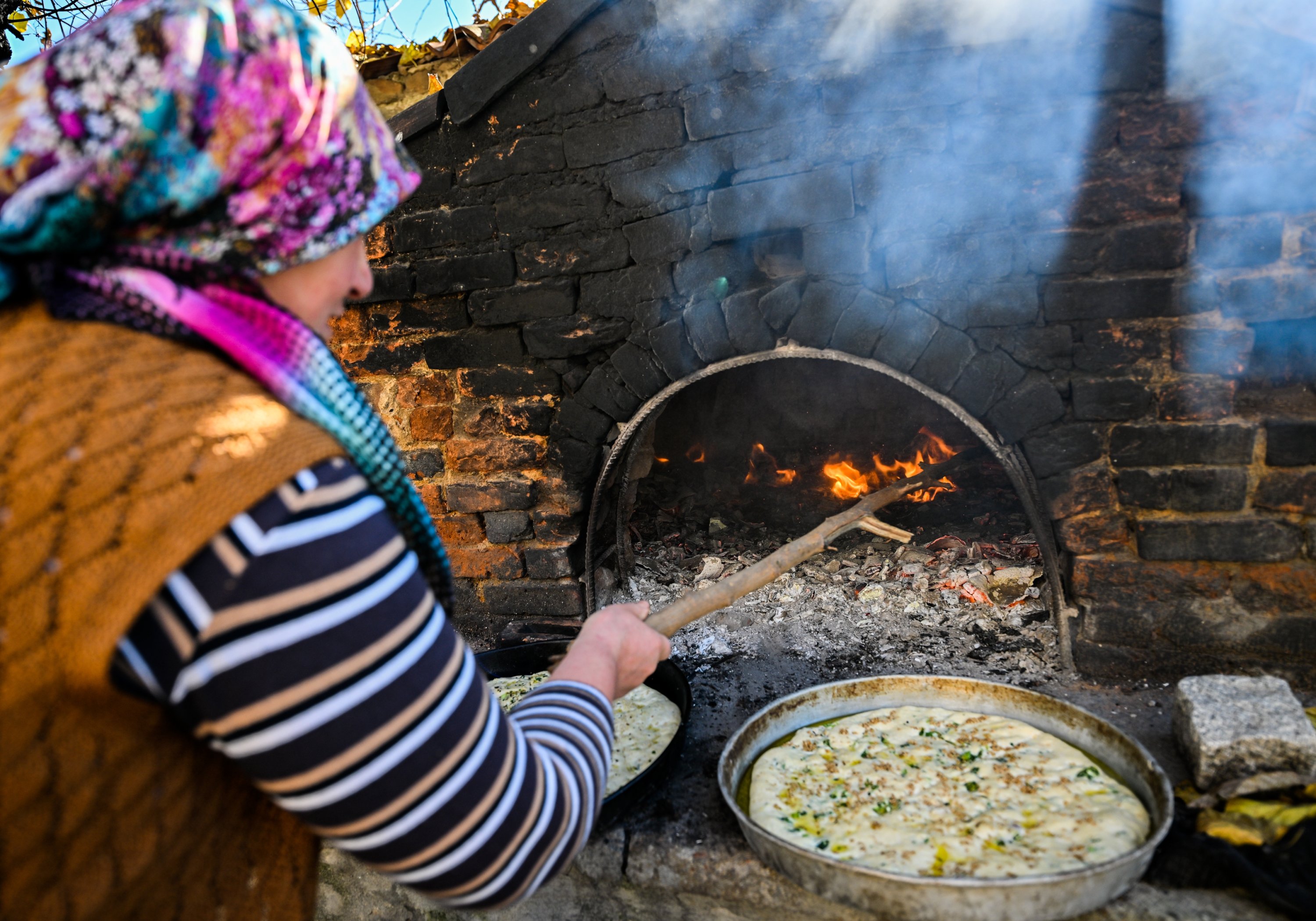 One of the villagers cooks homemade pita in the wood fire, Izmir, Türkiye, Dec. 21, 2022. (AA Photo)
