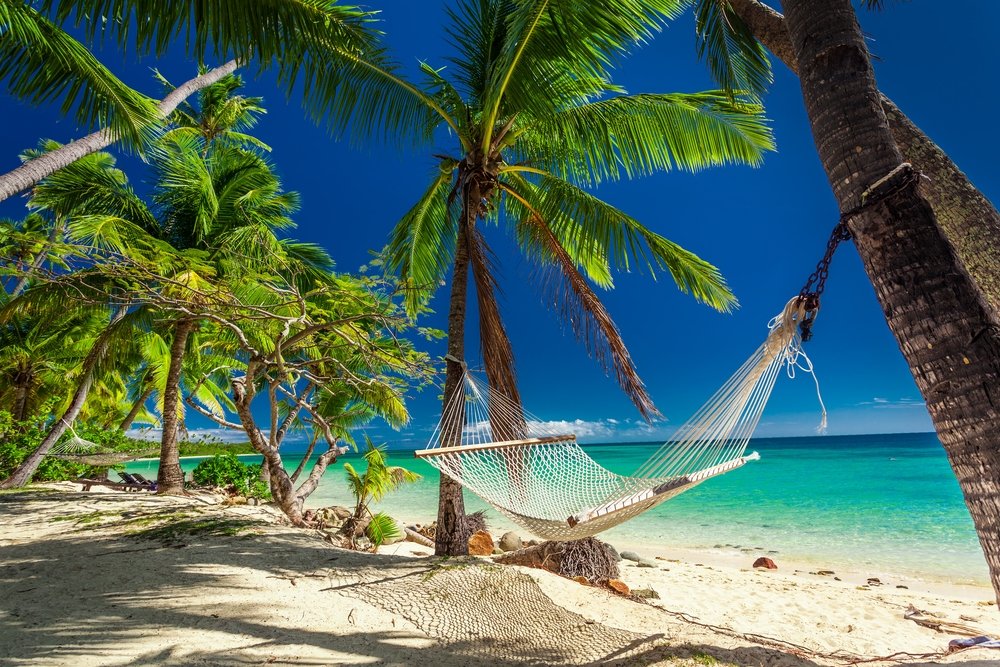 Empty hammock in the shade of palm trees on tropical Fiji Islands. (Shutterstock Photo)