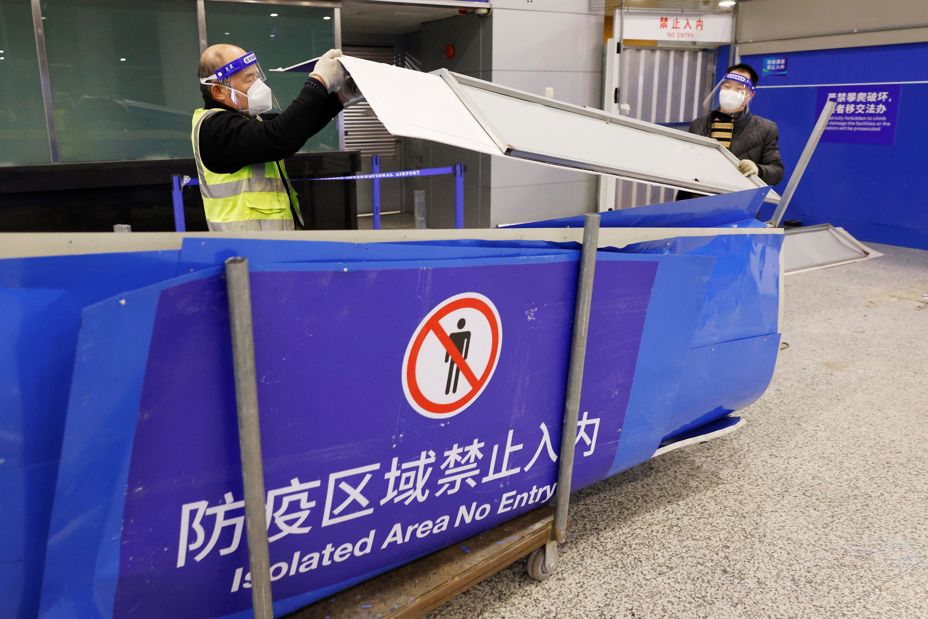 İşçiler, Şangay Pudong Uluslararası Havalimanı'nın dış hatlar geliş salonundaki karantina bariyerlerini kaldırıyor, Şanghay, Çin, 7 Ocak 2023. (Reuters Fotoğrafı)