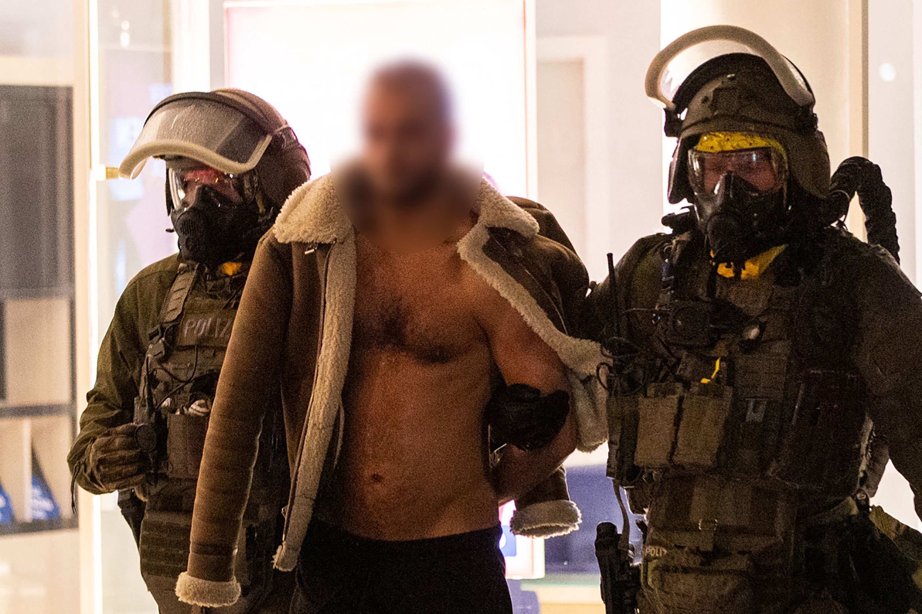 Seorang pria (tengah) dibawa pergi setelah ditangkap oleh petugas polisi Satuan Tugas Khusus (SEK) yang mengenakan alat pelindung diri di Castrop-Rauxel, Jerman barat, 8 Januari 2023. (Foto AFP)