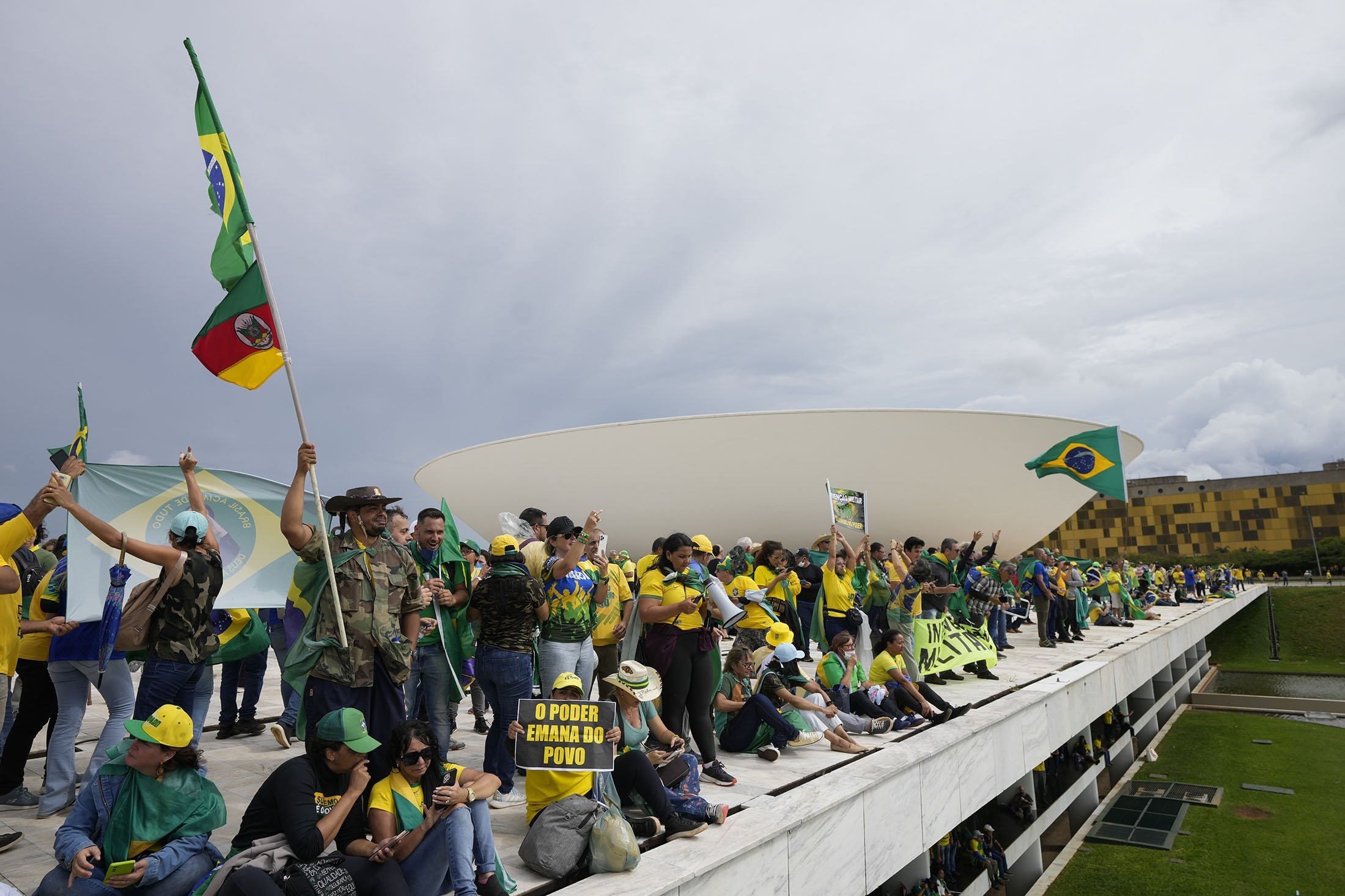 Brezilya'nın eski Devlet Başkanı Jair Bolsonaro'nun destekçileri olan protestocular, 8 Ocak 2023'te Brezilya'nın Brasilia kentinde Ulusal Kongre binasına baskın düzenledikten sonra çatısında duruyorlar. (AP Fotoğrafı)