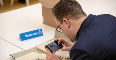 A journalist takes pictures of a map with details of a possible Nazi treasure in Ommeren during the annual Open Access Day of the National Archives in The Hague, Netherlands, Jan. 3, 2023. (EPA Photo)