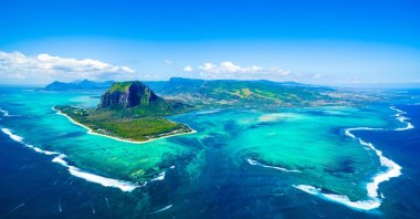 Aerial view of Mauritius island panorama and famous Le Morne Brabant mountain, beautiful blue lagoon and underwater waterfall. (Shutterstock Photo)