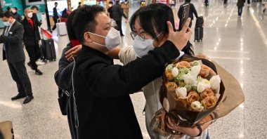A passenger (R) receives a hug at the arrival area of international flights at the Shanghai Pudong International Airport, Shanghai, China, Jan. 8, 2023. (AFP Photo)