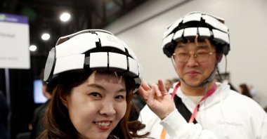 Minjung Kim (L) and Kyng Nam Kim (R) of iMediSync Inc., wear the the new consumer version of iMedisync's iSyncWave for digital brain health monitoring with AI brain mapping and LED therapy, during the CES Unveiled press event at CES 2023 in Las Vegas, Nevada, U.S., Jan. 3, 2023. (Reuters Photo)