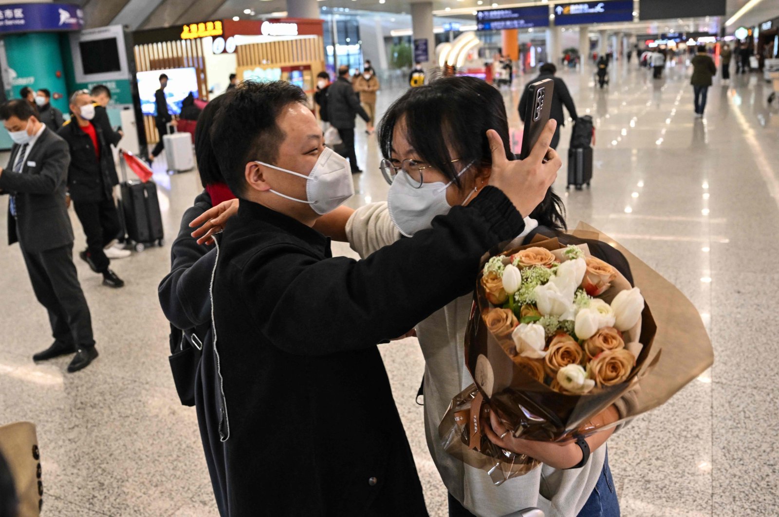 A passenger (R) receives a hug at the arrival area of international flights at the Shanghai Pudong International Airport, Shanghai, China, Jan. 8, 2023. (AFP Photo)