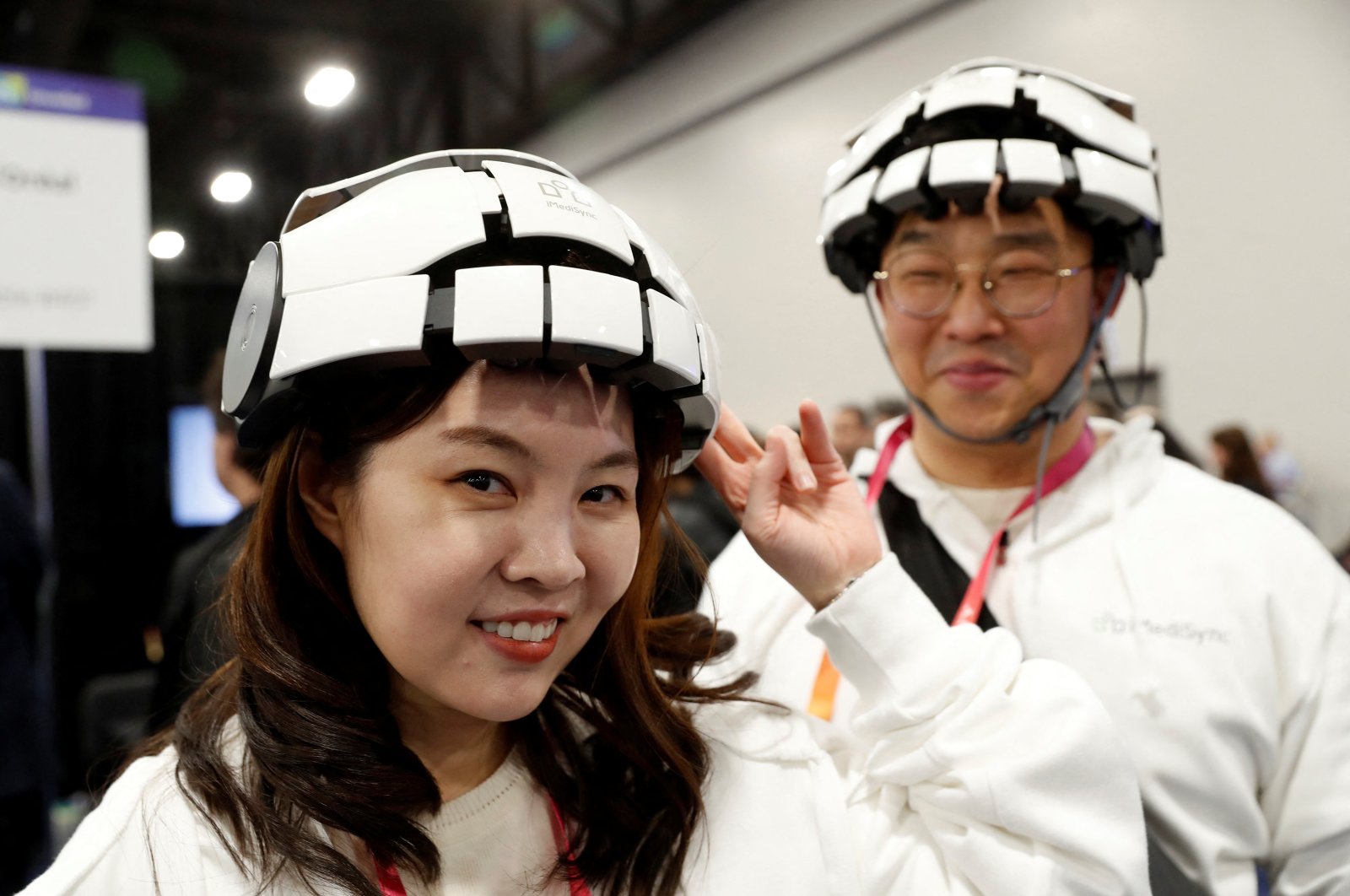 Minjung Kim (L) and Kyng Nam Kim (R) of iMediSync Inc., wear the the new consumer version of iMedisync&#039;s iSyncWave for digital brain health monitoring with AI brain mapping and LED therapy, during the CES Unveiled press event at CES 2023 in Las Vegas, Nevada, U.S., Jan. 3, 2023. (Reuters Photo)