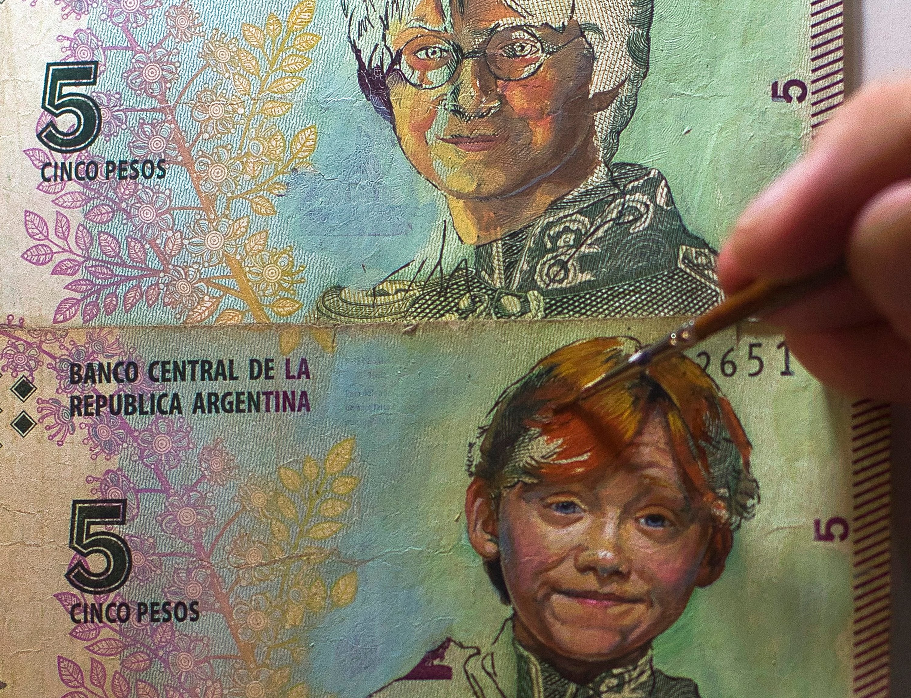 Artist Sergio Diaz intervenes Argentine pesos bills with portraits of characters from the movie 