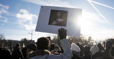 A protester holds a picture of Mahsa Amini during a rally demanding justice for the passengers of Ukraine International Airlines Flight PS752 in Ottawa, Ontario, Jan. 8, 2023. (AP Photo)