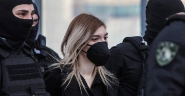 Roula Pispirigou (C), a 34-year-old mother accused of killing her three daughters, is escorted by police officers to Athens courthouse, Athens, Greece, Jan. 9, 2023. (AFP Photo)