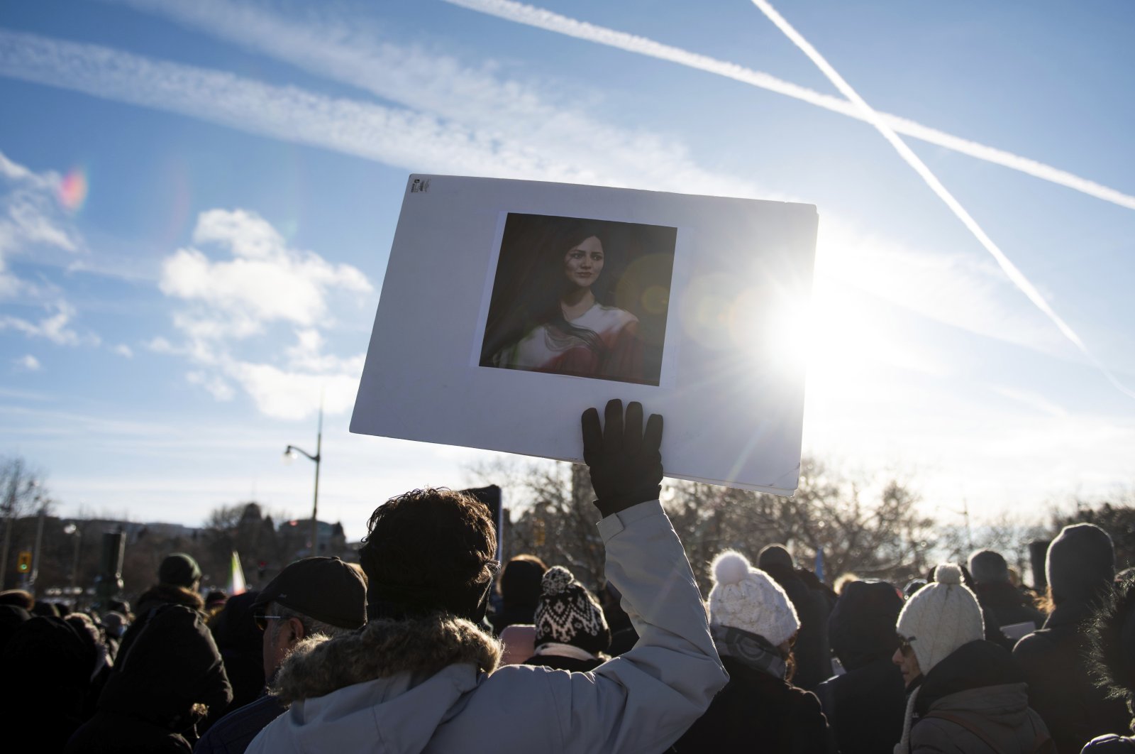 A protester holds a picture of Mahsa Amini during a rally demanding justice for the passengers of Ukraine International Airlines Flight PS752 in Ottawa, Ontario, Jan. 8, 2023. (AP Photo)