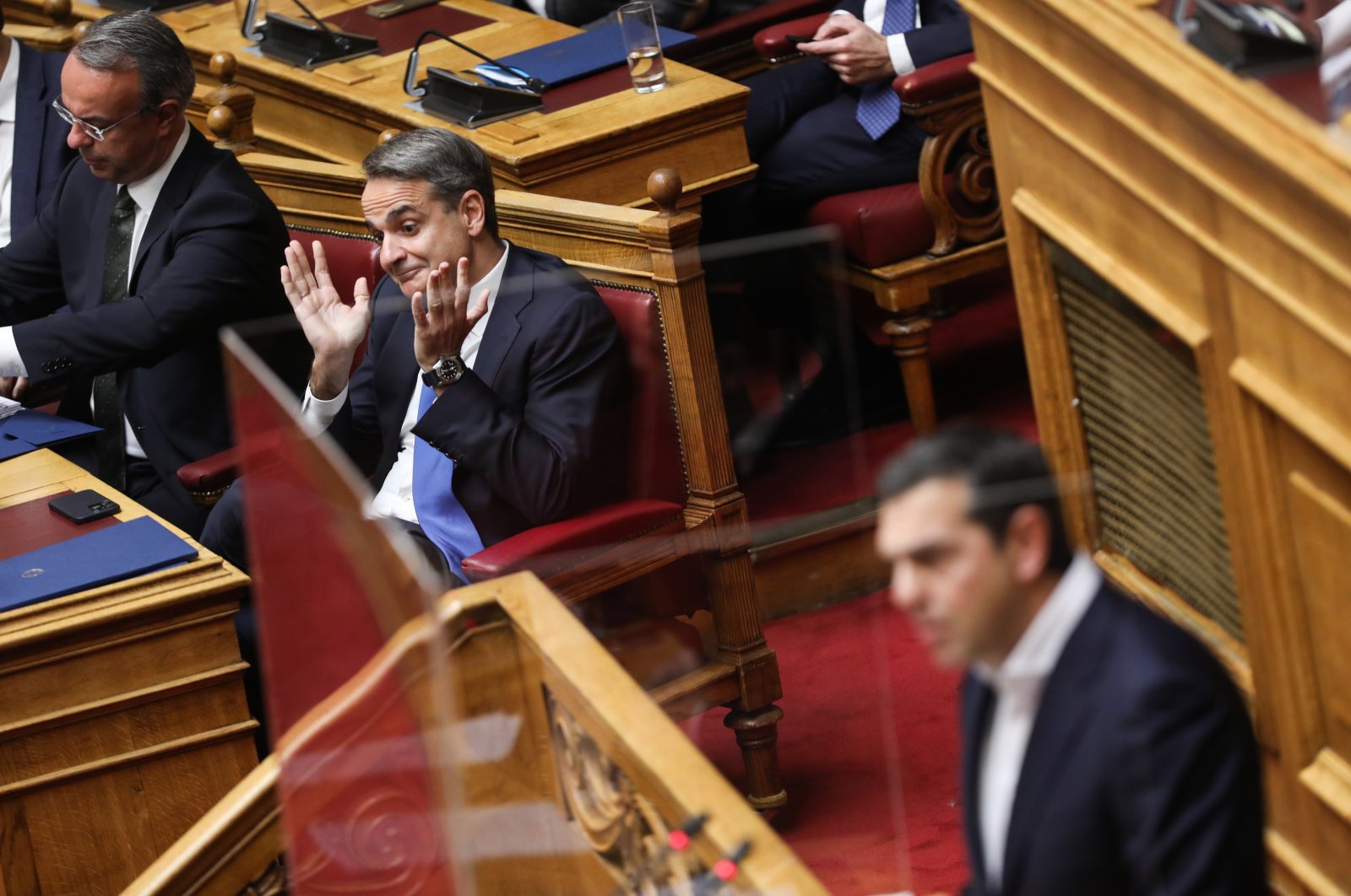 Greek Prime Minister Kyriakos Mitsotakis (2-L) reacts as he listens to the speech of Alexis Tsipras (R), leader of the main opposition party Syriza, during a parliamentary debate prior to a vote on the 2023 state budget, Athens, Greece, Dec. 17, 2022. (EPA Photo)