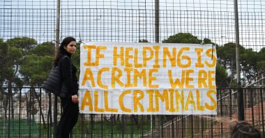 People hold banners during a protest in support of the 24 defendants facing trial over refugee rescues, outside a courthouse in Mytilene, Lesbos, Greece, Jan. 10, 2023. (EPA Photo)