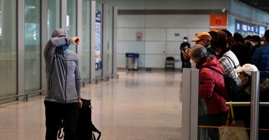 A passenger covers his face at the arrivals area for international flights at the Capital International Airport in Beijing on Jan. 8, 2023. (AFP Photo)