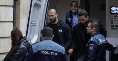 Andrew Tate (C-L) and his brother Tristan (C-R) are escorted by police officers outside the headquarters of the Bucharest Court of Appeal, in Bucharest, Romania, Jan. 10, 2023. (Reuters Photo)