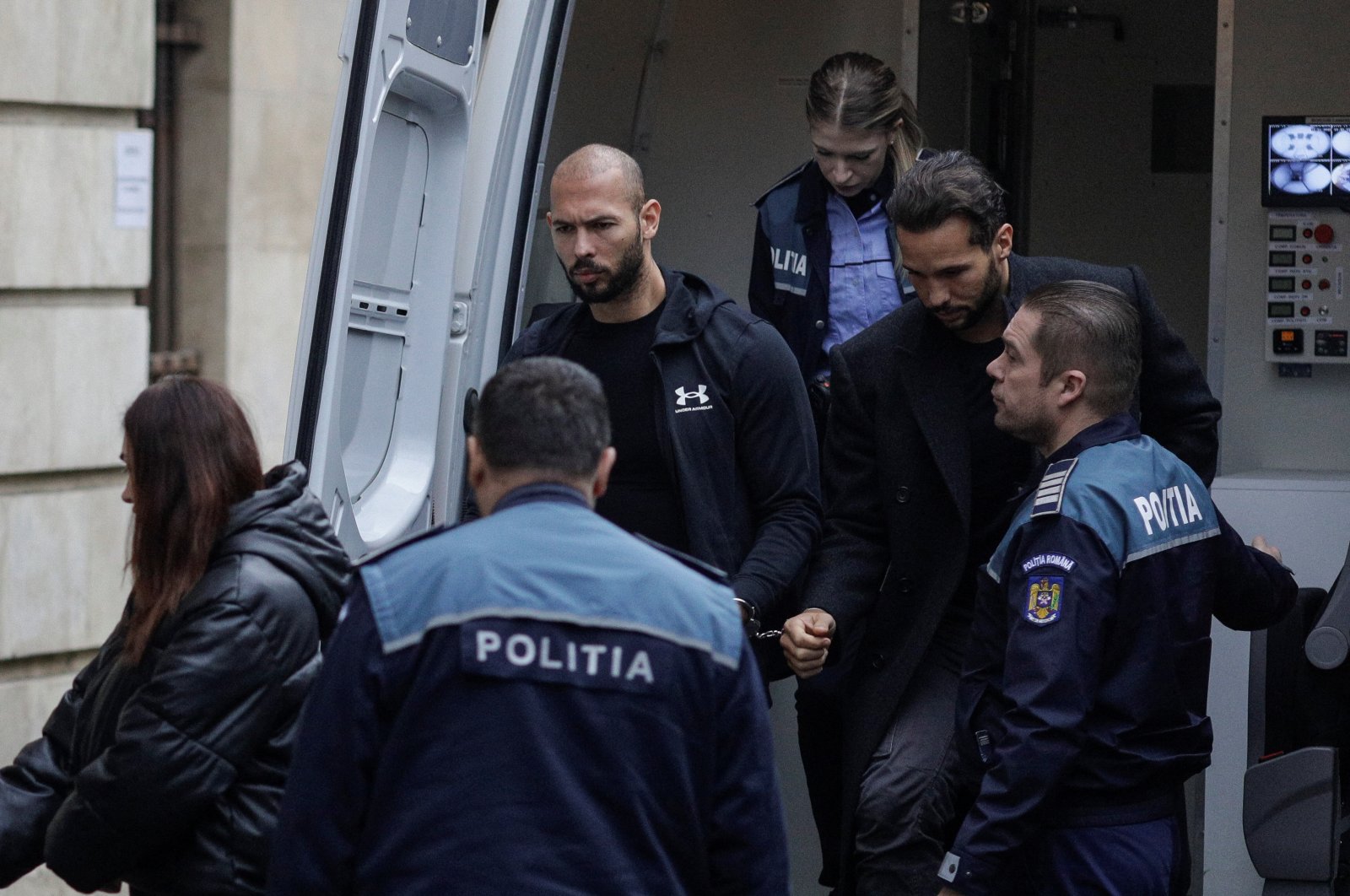 Andrew Tate (C-L) and his brother Tristan (C-R) are escorted by police officers outside the headquarters of the Bucharest Court of Appeal, in Bucharest, Romania, Jan. 10, 2023. (Reuters Photo)