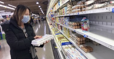 A shopper checks eggs before she buys at a grocery store in Glenview, Illinois, U.S., Jan. 10, 2023. (AP Photo)