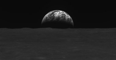 A black-and-white image of the lunar surface and Earth taken by South Korean lunar orbiter Danuri after reaching the moon&#039;s orbit, Dec. 31, 2022. (AFP Photo)
