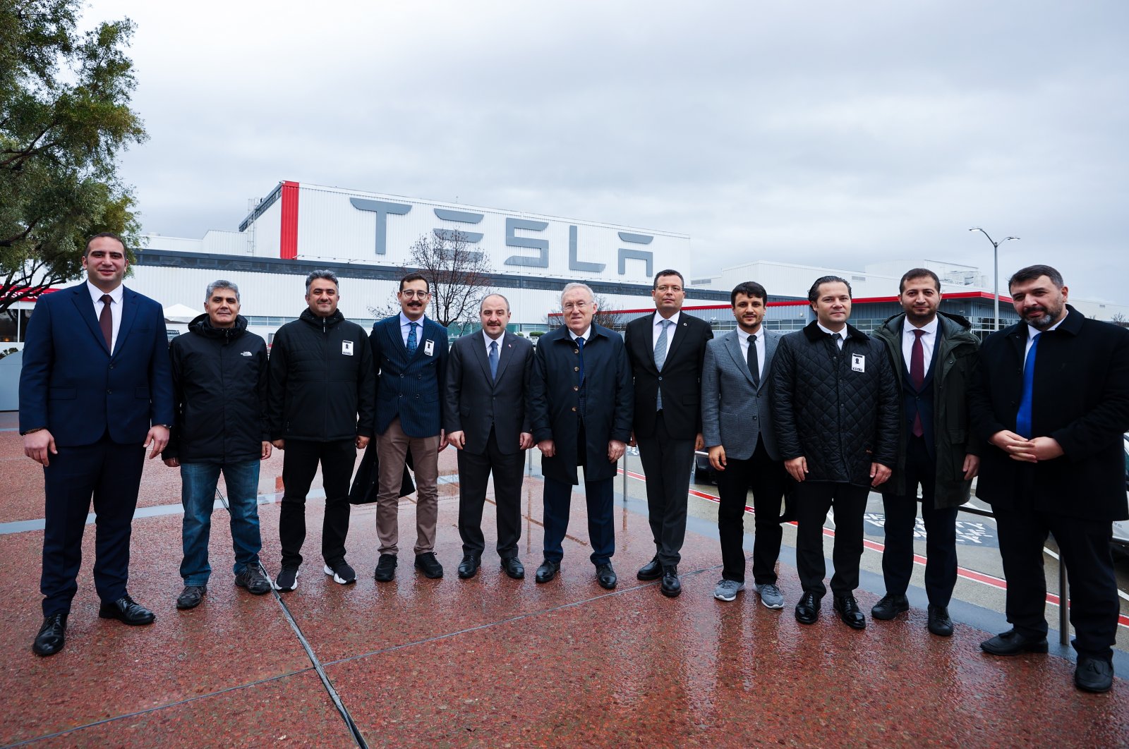 Industry and Technology Minister Mustafa Varank (5th from L) and other officials pose for a photo with the Tesla Fremont Factory in the background, in Fremont, California, U.S., Jan. 10, 2022. (AA Photo)

