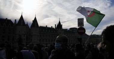 A demonstrator holds an Algerian flag during a tribute march in Paris, France, Oct. 17, 2021. (AP Photo)