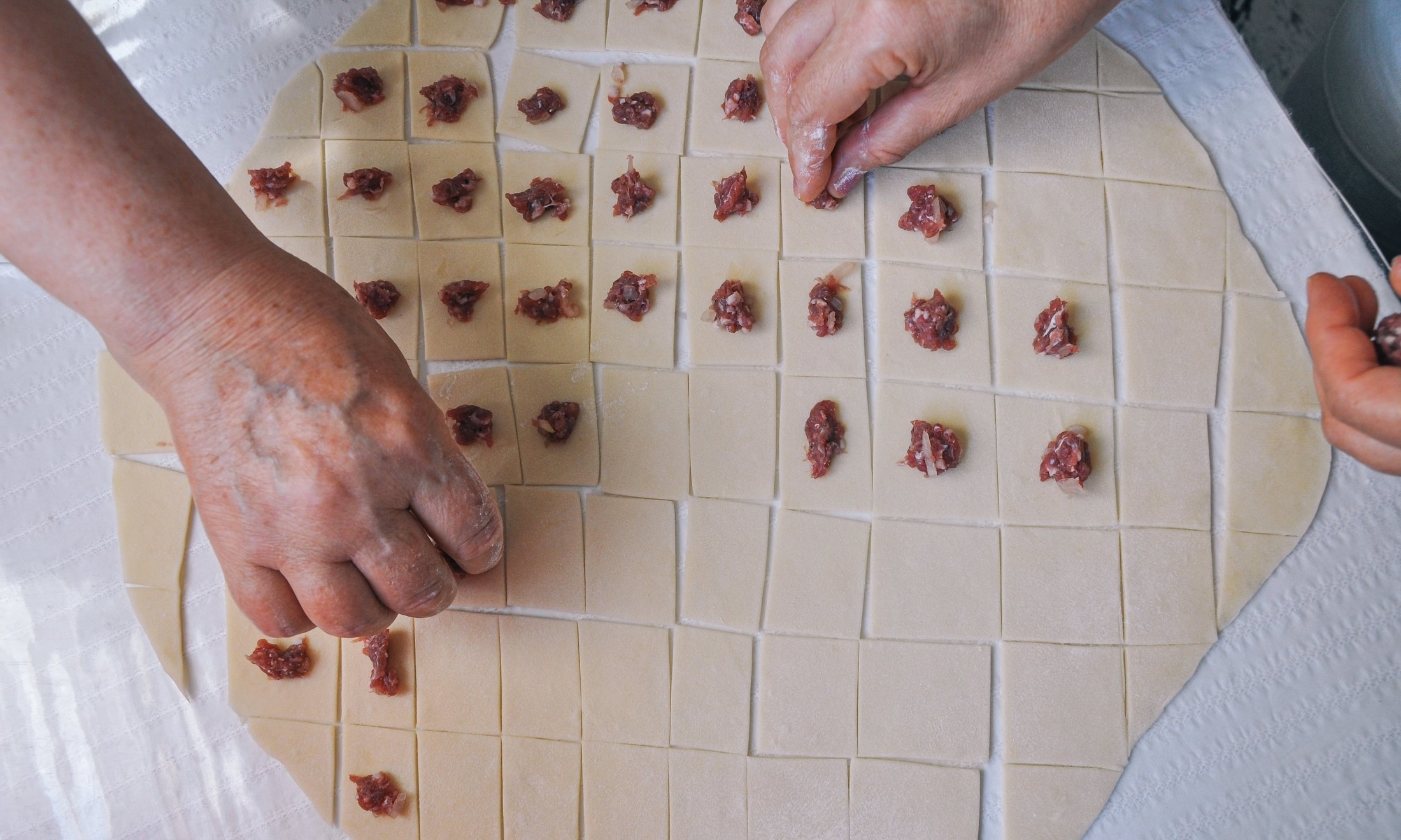Women make traditional Turkish mantı. (Shutterstock Photo)