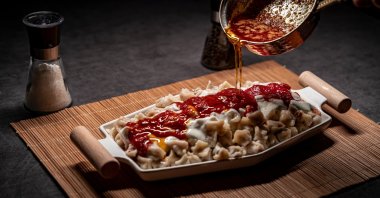 Traditional Turkish mantı with yogurt and tomato sauce. (Shutterstock Photo)