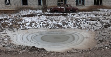 Ice covers a bomb crater in the town of Siversk, Donetsk region, as the Russia-Ukraine war enters its 324th day, Jan. 13, 2023. (AFP Photo)