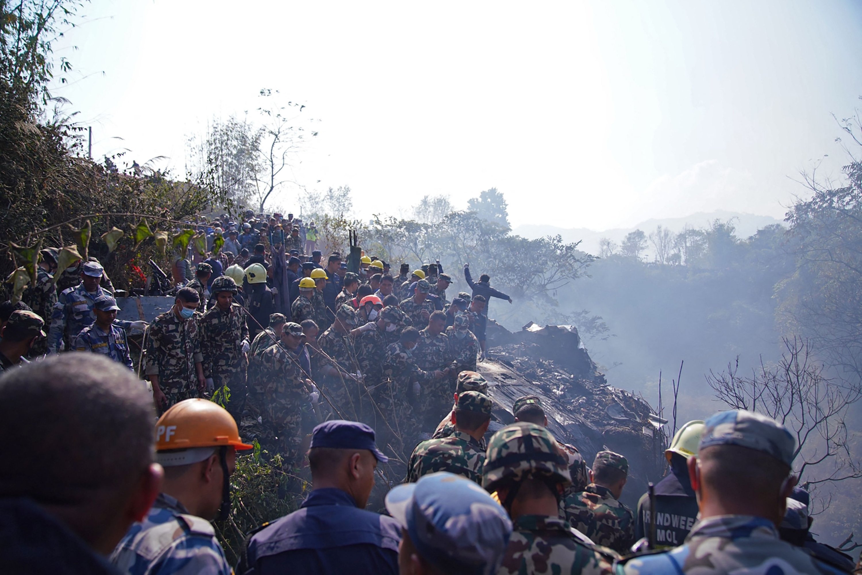 Tim penyelamat bekerja untuk mengevakuasi jenazah di lokasi jatuhnya pesawat yang membawa 72 orang di Pokhara, Nepal, 15 Januari 2023. (AFP Photo)