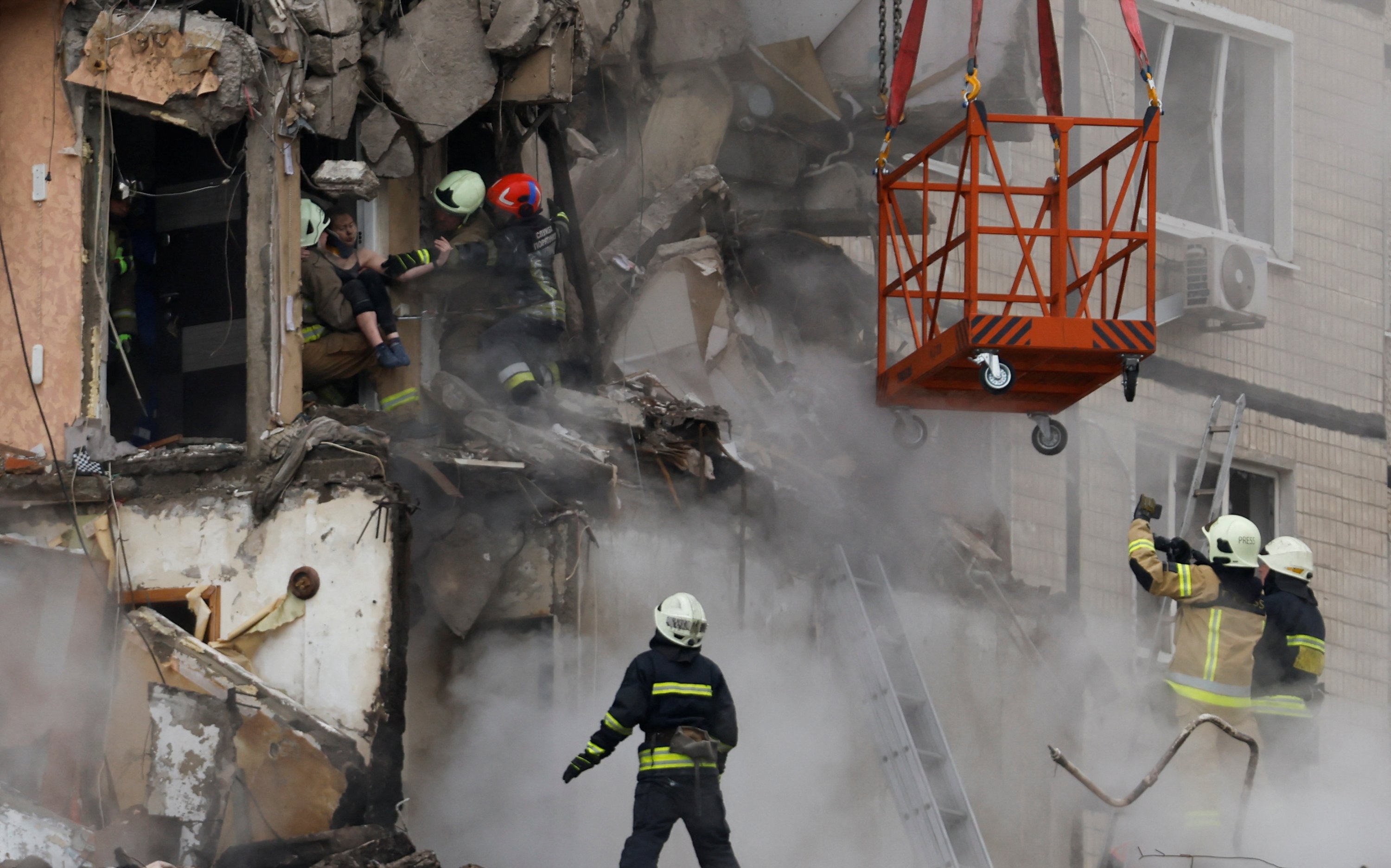 Petugas darurat mengevakuasi seseorang dari blok apartemen yang rusak parah akibat serangan rudal Rusia, Dnipro, Ukraina, 15 Januari 2023. (Foto Reuters)