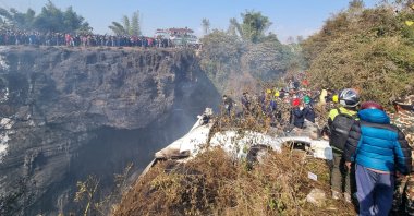 Crowds gather as rescue teams work to retrieve bodies at the crash site of an aircraft carrying 72 people in Pokhara, Nepal, Jan. 15, 2023. (Reuters Photo)