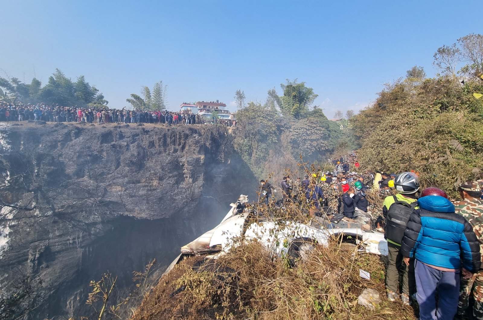 Crowds gather as rescue teams work to retrieve bodies at the crash site of an aircraft carrying 72 people in Pokhara, Nepal, Jan. 15, 2023. (Reuters Photo)