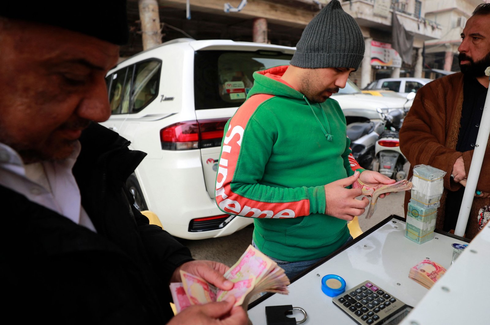 A street money exchanger counts banknotes at the al-Kifah stock market in Baghdad, Iraq, Dec. 27, 2022. (AFP Photo)