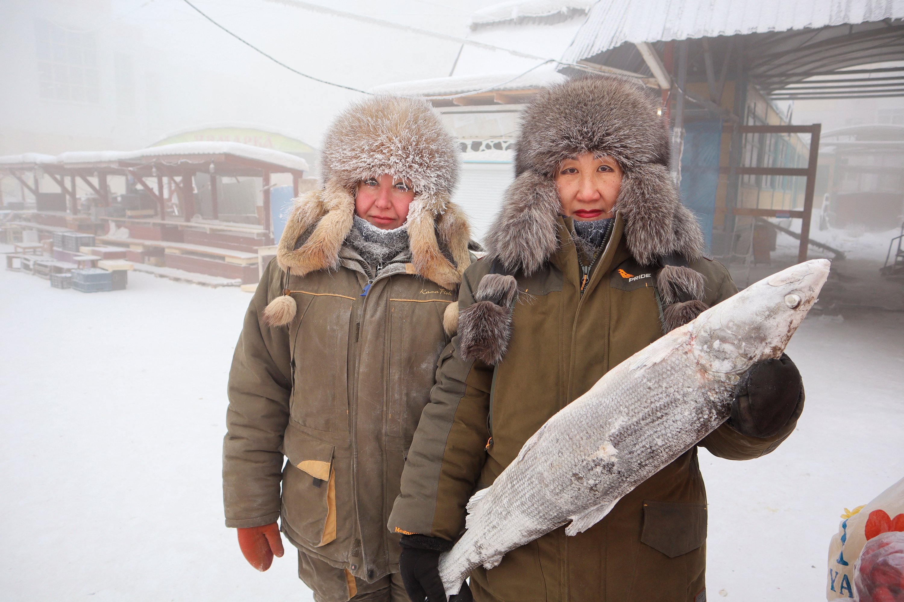 Penjual ikan Marina Krivolutskaya dan Marianna Ugai berfoto di pasar terbuka pada hari yang sangat dingin di Yakutsk, Rusia, 15 Januari 2023. (Foto Reuters)