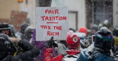 A climate activist displays a placard during a protest ahead of the World Economic Forum (WEF) 2023 in the Alpine resort of Davos, Switzerland, Jan. 15, 2023. (Reuters Photo)