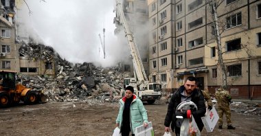 Residents carry their belongings from a residential building destroyed after a missile strike, in Dnipro, Ukraine, Jan. 15, 2023. (AFP Photo)