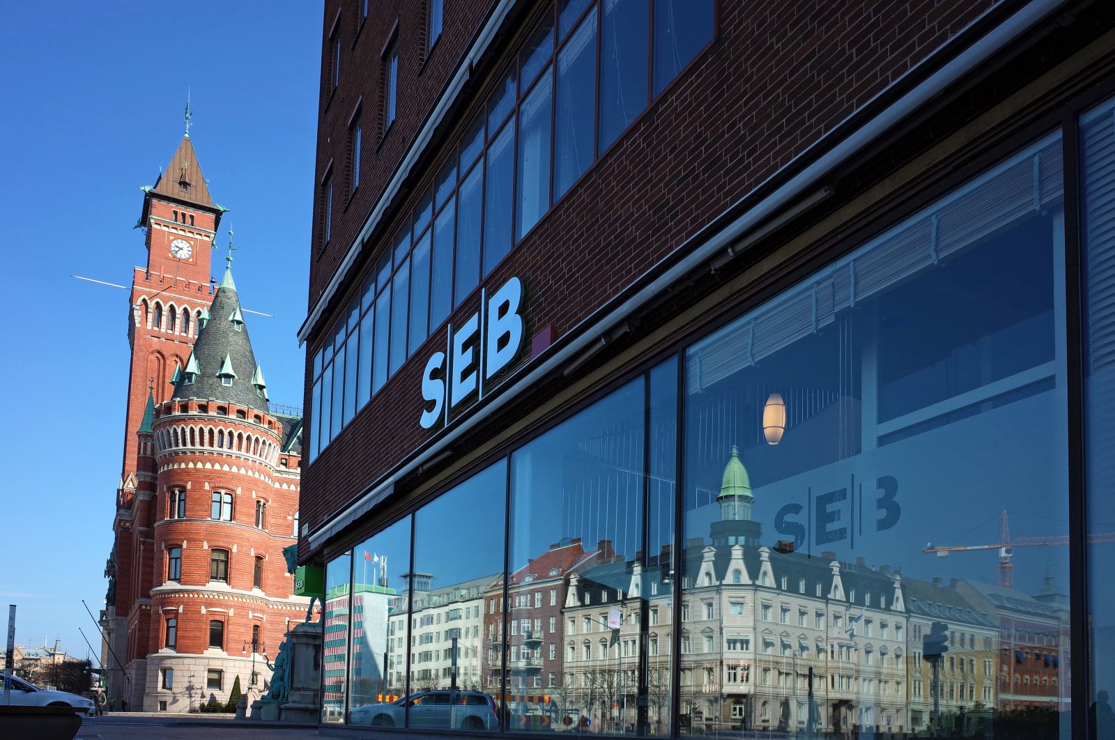 The SEB bank building on Jarnvagsgatan Street with the clock tower of Town Hall in the background, Helsingborg, Sweden. April 14, 2018. (Shutterstock Photo)