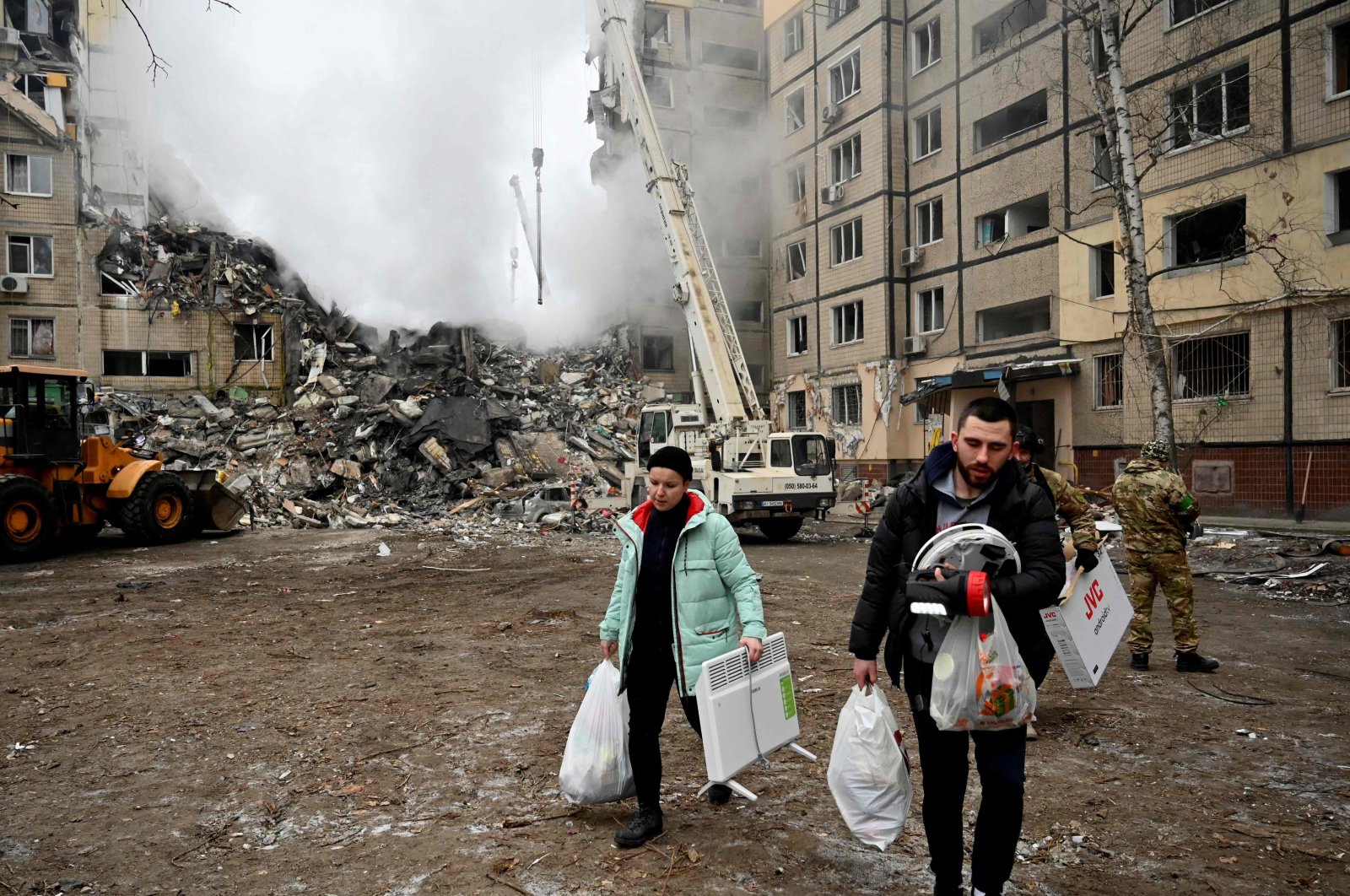 Residents carry their belongings from a residential building destroyed after a missile strike, in Dnipro, Ukraine, Jan. 15, 2023. (AFP Photo)
