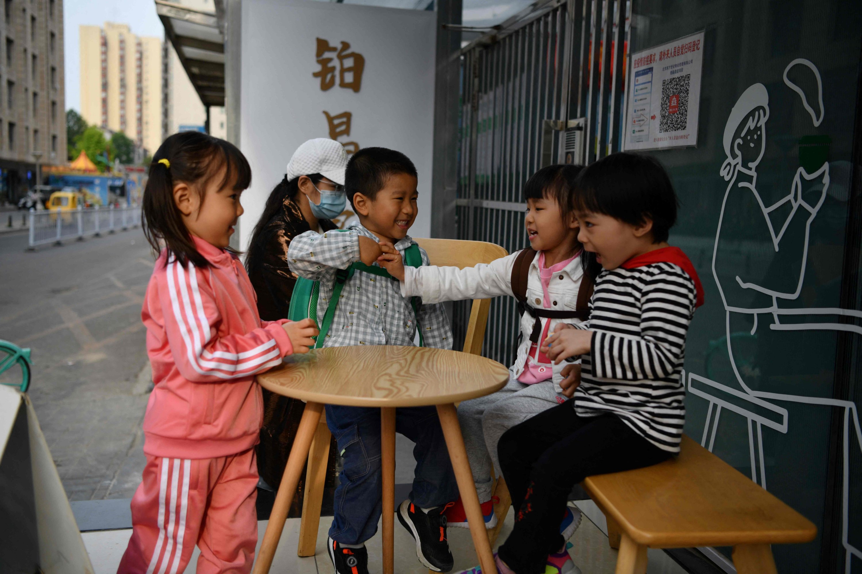 Anak-anak bermain di luar kafe di Beijing, China, 11 Mei 2021. (Foto AFP)