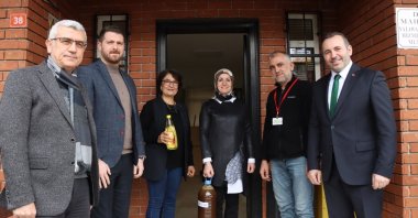 Yalova Municipality council members holding used 5-liter cooking oil and a new 1 liter of sunflower oil, Yalova, Türkiye, Jan. 17, 2023. (AA Photo)