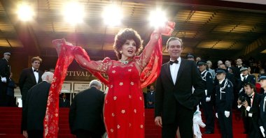 Italian actress Gina Lollobrigida (C) waves to the crowd during red-carpet arrivals with French Culture Minister Jean-Jacques Aillagon (C Rear) for the screening of the remake of "Fanfan la Tulipe" by [French director Gerard Krawczyk] on the opening night of the 56th International Film Festival in Cannes, France, May 14, 2003. (Reuters Photo)