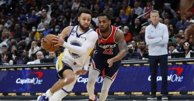 Golden State Warriors guard Stephen Curry (L) drives to the basket as Washington Wizards guard Monte Morris (R) defends in the second quarter at Capital One Arena. Washington, USA, Jan 16, 2023. (Reuters Photo)