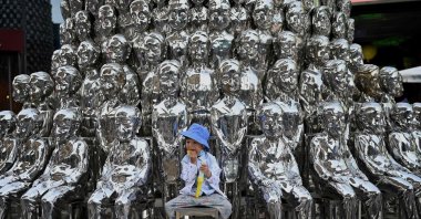 A boy sits on a chair amongst sculptures on display at a shopping center on International Children's Day in Beijing, June 1, 2021. (AFP Photo)