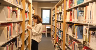 Fatma Zehra S, a Turkish student whose internship application was rejected by Stockholm University professor, reads a book at a library in Istanbul, Jan. 17, 2023. (AA Photo)